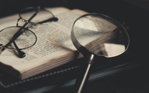 A book, glasses, and a magnifying glass